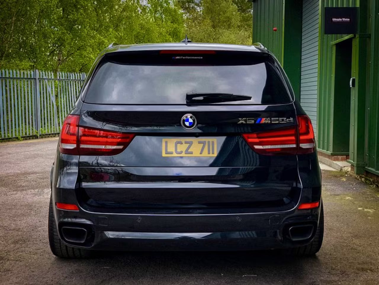 Black BMW SUV with visible license plate in an outdoor setting