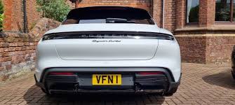 White car with a yellow license plate 'VFN' on a driveway.